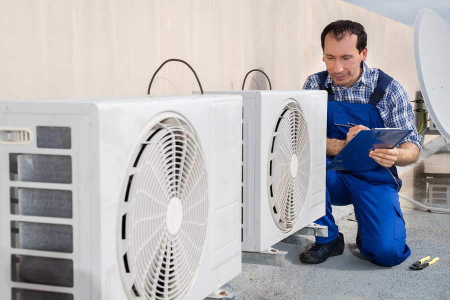 worker crouching near the air conditioner