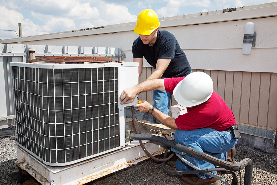 two workers checking the air conditioner